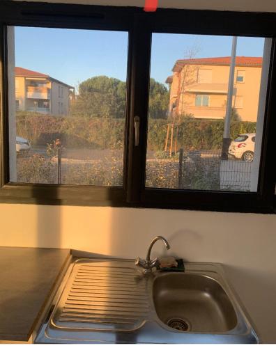 a kitchen sink with a view of a street at Studio indépendant in Perpignan