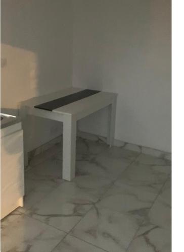 una mesa blanca en la parte superior de un suelo de baldosa en Studio indépendant, en Perpiñán