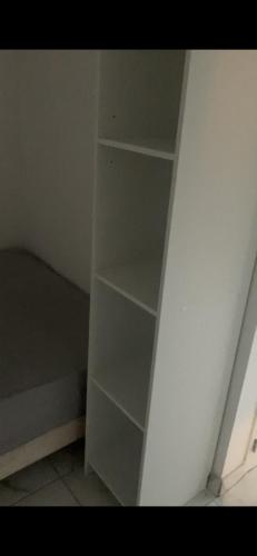 un estante blanco en la esquina de una habitación en Studio indépendant, en Perpiñán