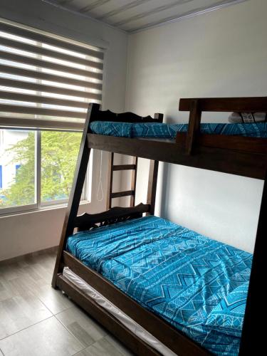 two bunk beds in a room with a window at Casa vacacional Carmen de apicala in Carmen de Apicalá