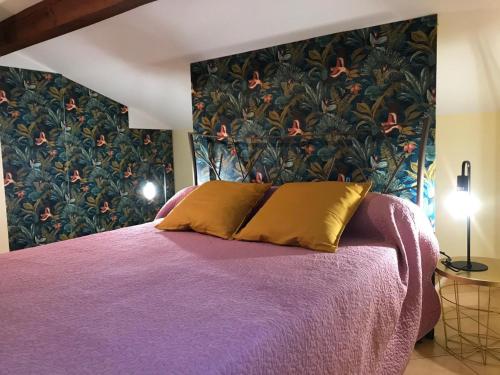 ein Schlafzimmer mit einem lila Bett mit Blumentapete in der Unterkunft Chori-ekin in Ustaritz