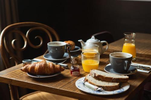 a table with a breakfast of coffee and bread and orange juice at Relais de la Loire in Montlivault