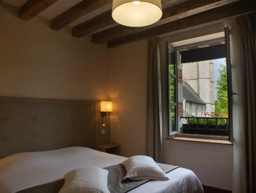 um quarto com uma cama e uma janela em Relais de la Loire em Montlivault