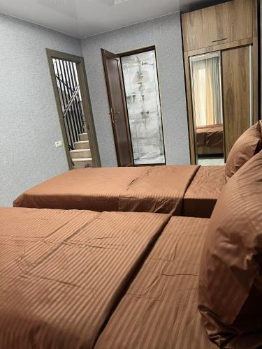 a bedroom with two beds and a staircase in the background at Villa for families and friends 2 in Tbilisi City