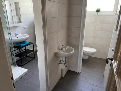 a bathroom with a sink and a toilet at Hotel & Apartment Am Theaterplatz in Bremerhaven