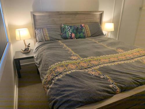 a large bed in a bedroom with a table and two lamps at dhu drop inn in Cervantes