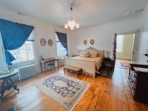 Un dormitorio con una cama y una mesa. en The Borland House Inn, en Montgomery