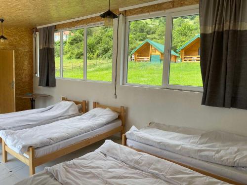2 Betten in einem Zimmer mit 2 Fenstern in der Unterkunft Gusinje View in Gusinje