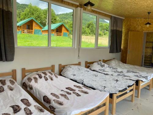 two beds in a room with two windows at Gusinje View in Gusinje