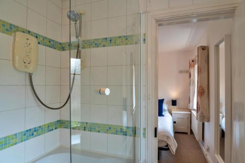 a bathroom with a shower with a glass door at Finest Retreats - Bamboo Cottage in Timberscombe