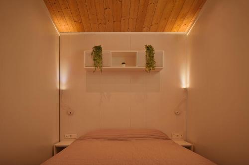 ein Schlafzimmer mit einem Bett und zwei Pflanzen auf Regalen in der Unterkunft Modernes Tiny House -neu 2021- in Uigendorf