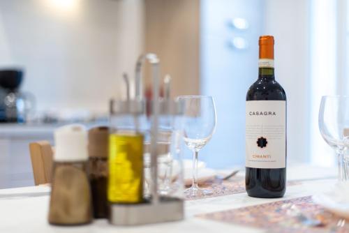 eine Flasche Wein auf einem Tisch mit Brille in der Unterkunft Luxury Home Il Giglio in Florenz