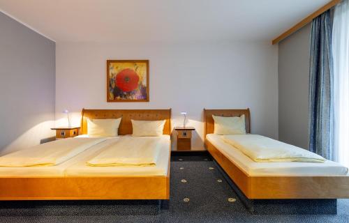 two beds in a bedroom with two lamps on tables at Kassel Ost in Kassel