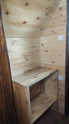 a wooden cabin with a bench in the corner at Cottage Bosaca in Žabljak