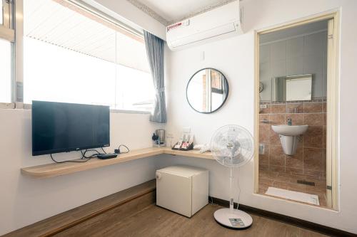 ein Wohnzimmer mit einem TV und einem Ventilator in der Unterkunft 池上大地飯店 in Chishang