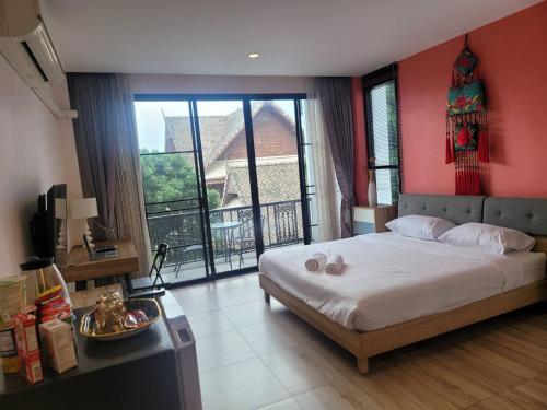 una camera con un grande letto con una parete rossa di THAI HOTEL CHIANGMAI a Chiang Mai