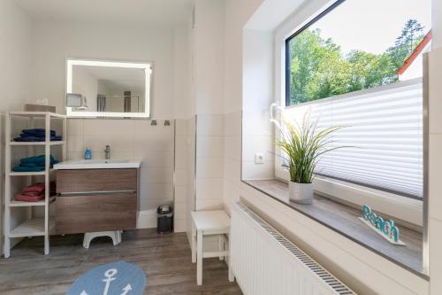a bathroom with a sink and a window at Haus Hamburg Wohnung 1 in Hohwacht