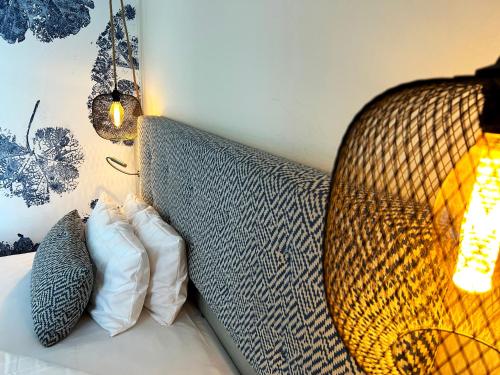 a couch with two pillows sitting next to a lamp at Safranberg Hotel & Sauna in Ulm