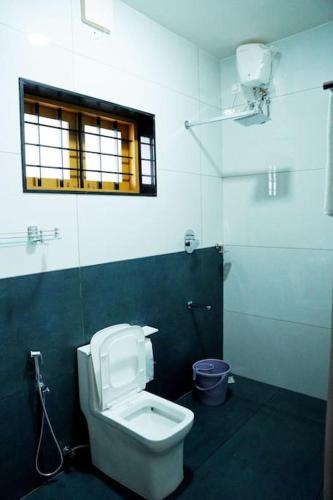a bathroom with a toilet and a window at Crystal Villa Suite2 First Floor in Cochin