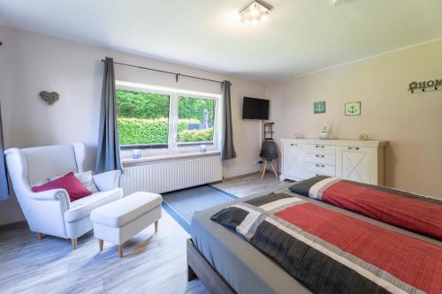 1 dormitorio con 1 cama, 1 silla y 1 ventana en Haus Hamburg Wohnung 1, en Hohwacht