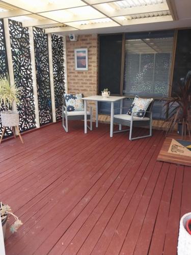 a patio with a table and chairs on a deck at The Treasure Box in Esperance