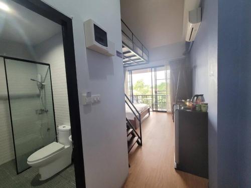 1 dormitorio y baño con aseo y ducha. en THAI HOTEL CHIANGMAI, en Chiang Mai