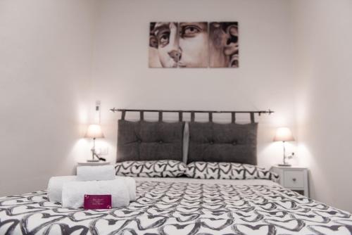 ein Schlafzimmer mit einem schwarzen und weißen Bett mit zwei Lampen in der Unterkunft Luxury Home Il Giglio in Florenz