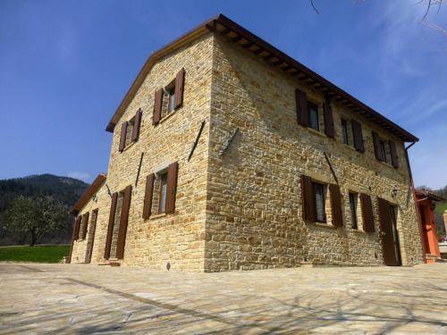 a large brick building with windows on the side of it at Country House Le Grazie in Serra San Quirico