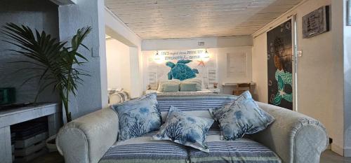 a living room with a couch with blue pillows at Cozy Guest in Graskop
