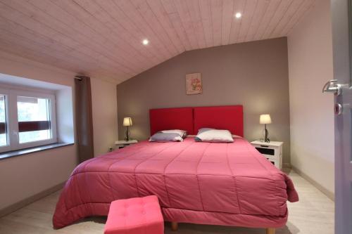 a bedroom with a large bed with a red bedspread at Bidainia in Ainhice-Mongelos