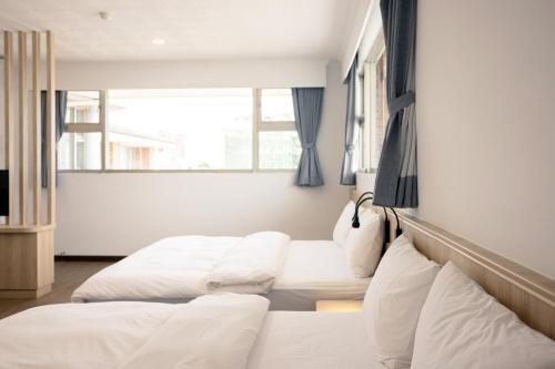 a bedroom with two beds and a window at 池上大地飯店 in Chishang