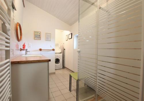 a bathroom with a sink and a washing machine at Bidainia in Ainhice-Mongelos