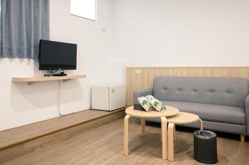 a living room with a couch and a table and a tv at 池上大地飯店 in Chishang