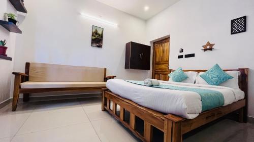 a bedroom with a bed and a bench in it at THE LUXE HOTEL, ECR ROAD, NEAR Serenity Beach, Pondicherry - JR Groups in Puducherry