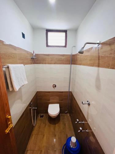 a bathroom with a toilet and a glass shower at THE LUXE HOTEL, ECR ROAD, NEAR Serenity Beach, Pondicherry - JR Groups in Puducherry