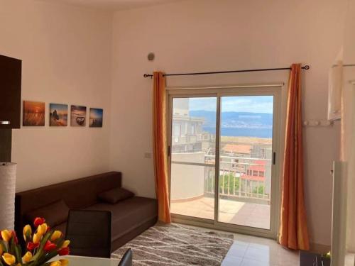 una sala de estar con una gran puerta corredera de cristal en Blue Sea Apartment, en Messina