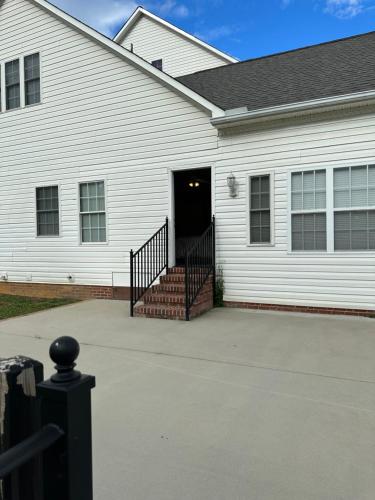 Casa blanca con una escalera que conduce a una puerta en MooreField Suites Greensboro East, en McLeansville