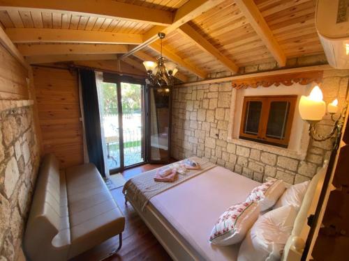 a bedroom in a log cabin with a bed and a couch at Aral Turkuaz in Cesme