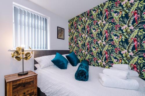 a bedroom with a bed with blue pillows on it at 4 bed property, Bolton , Manchester in Egerton