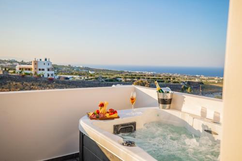 a hot tub on a balcony with a view of the ocean at Bonsai Luxury Suites in Karterados