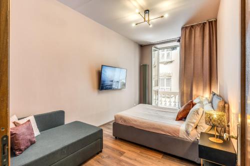 a bedroom with a bed and a couch and a window at DOWNTOWN SRL - Cinque Terre Dream in La Spezia