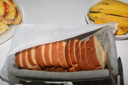 a loaf of bread in a pan next to a plate of bananas at Pousada Mare Blue in Búzios