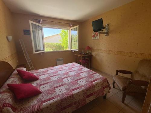 a bedroom with a bed with red pillows and a window at Les Oliviers in Montagnac