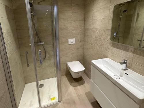 uma casa de banho com um chuveiro, um WC e um lavatório. em Alivu - Appartement Moderne Avec Terrasse em Cargèse