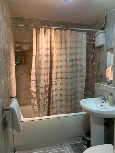 ein Badezimmer mit einer Badewanne und einem Waschbecken in der Unterkunft Captivating 2-Bed House in Amesbury Salisbury in Amesbury