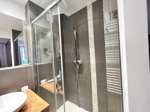 une douche avec une porte vitrée dans une salle de bain dans l'établissement ApartHotel Riviera - BALCON DES ETATS UNIS - Old Town Promenade des Anglais, à Nice