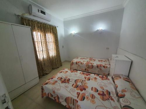 een kleine slaapkamer met 2 bedden en een raam bij ميرفيز هاوس Murphy's House in Hurghada