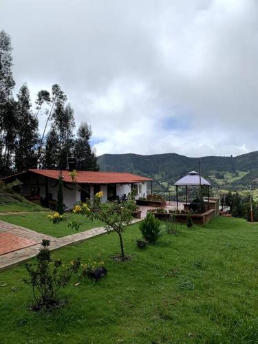 a house in a field with a grassy yard at Cabaña en la montaña de 3 Habitaciones in Sutatausa