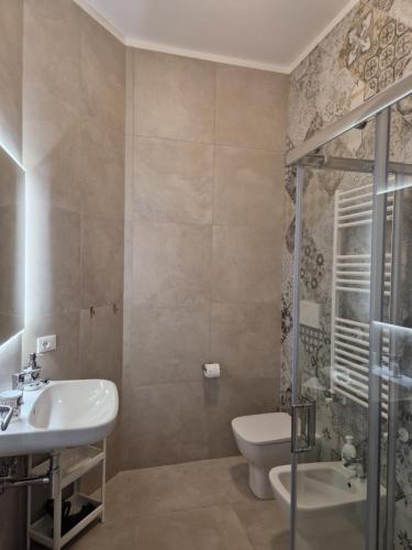 uma casa de banho com um WC, um lavatório e um chuveiro em City Center Suite em Termoli