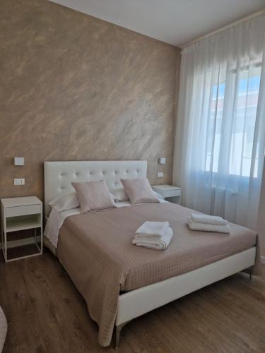 ein Schlafzimmer mit einem großen weißen Bett und einem Fenster in der Unterkunft City Center Suite in Termoli